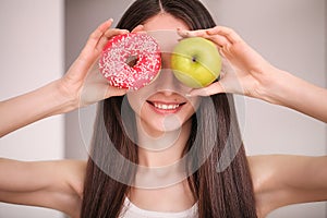 Diet. Woman Measuring Body Weight On Weighing Scale Holding Donut and apple. Sweets Are Unhealthy Junk Food. Dieting, Healthy Eat