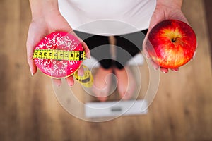 Diet. Woman Measuring Body Weight On Weighing Scale Holding Donut and apple. Sweets Are Unhealthy Junk Food. Dieting, Healthy Eat