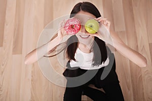 Diet. Woman Measuring Body Weight On Weighing Scale Holding Donut and apple. Sweets Are Unhealthy Junk Food. Dieting, Healthy Eat