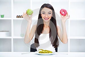 Diet. Woman Measuring Body Weight On Weighing Scale Holding Donut and apple. Sweets Are Unhealthy Junk Food. Dieting, Healthy Eat