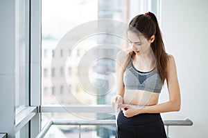 Diet, woman in sportswear measuring her waist, dieting concept