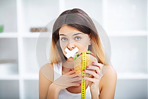 Diet. Young beautiful woman eating burger, It`s junk and unhealt