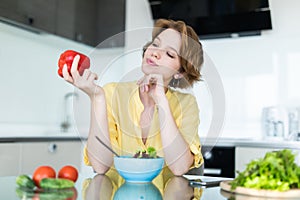 Diet. Young beautiful woman eating vegetable salad holding pepper in hands. Dieting concept. Healthy Food