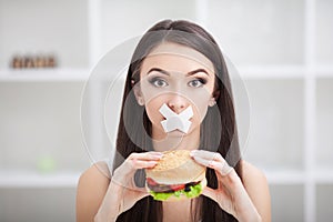 Diet. Young woman with duct tape over her mouth