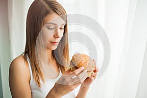 Diet. Young woman with duct tape over her mouth, preventing her to eat junk food. Healthy eating concept