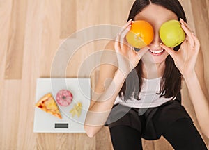 Diet. A young woman holding a pizza on the scales. The concept of healthy eating