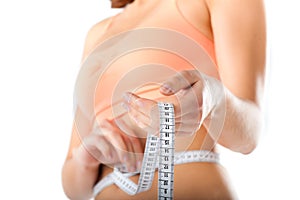 Diet - young woman is measuring her waist