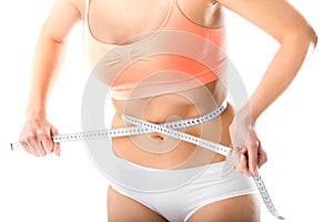 Diet - young woman is measuring her waist