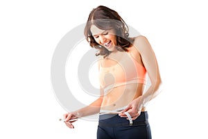 Diet - young woman is measuring her waist