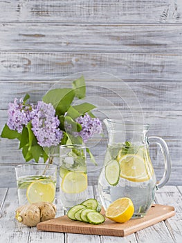 Dietary detox drink with lemon juice, ginger, cucumber and mint leaves in clear water