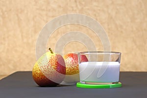 Dietary food. Dessert of milk. Milk product on a beige background. Creamy yogurt in a glass jar with fresh pears for a healthy di