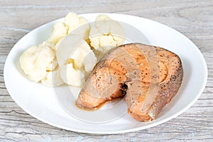 Dietary food. Steamed salmon steak and coliflower on a white plate photo