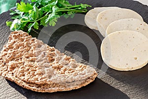 Dietary homemade chicken mortadella with allspice on slate board. Protein rye multicereal flatbread. Gray background