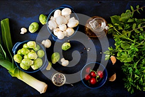 Dietary menu. Ingredients: Vegetables - Brussels sprouts, mushrooms, leeks and herbs on a dark background.