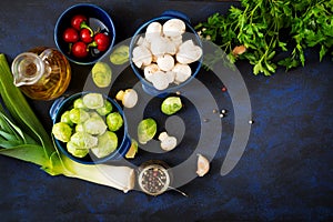 Dietary menu. Ingredients: Vegetables - Brussels sprouts, mushrooms, leeks and herbs on a dark background.