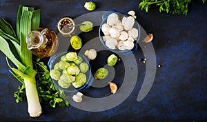 Dietary menu. Ingredients: Vegetables - Brussels sprouts, mushrooms, leeks and herbs on a dark background.