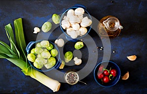 Dietary menu. Ingredients: Vegetables - Brussels sprouts, mushrooms, leeks and herbs on a dark background. Top view.