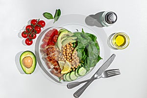 Dietary salad with chicken, avocado, cucumber, tomato and spinach. Hard light