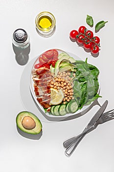 Dietary salad with chicken, avocado, cucumber, tomato and spinach. Hard light