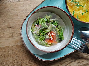 Dietary salad of fresh vegetables: cucumbers, radishes, tomatoes and broccoli, seasoned with olive oil.