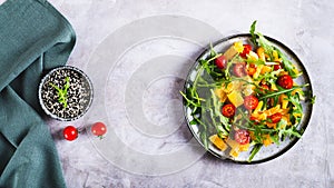 Dietary salad of orange slices, cherry tomatoes and arugula on a plate top view web banner