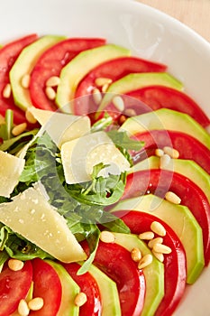 Dietary salad with zucchini, tomato, arugula and sliced parmesan