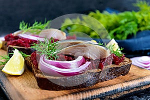 Dietary sandwiches with beets, slices of salted herring and red onion on rye bread