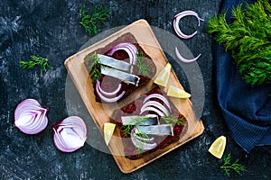 Dietary sandwiches with beets, slices of salted herring and red onion on rye bread