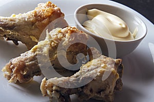 Dietary snack from chicken wings with homemade mayonnaise on white plate