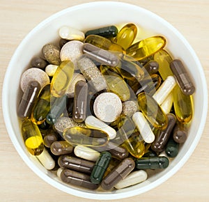 Dietary supplement capsules and tablets in bowl