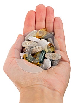 Dietary supplement capsules and tablets in hand