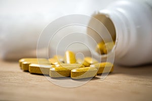 Dietary supplement tablets pouring out of container