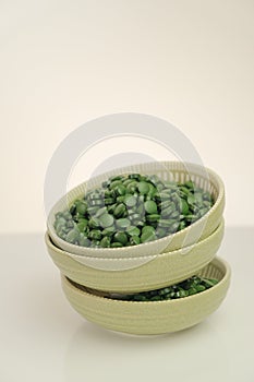 dietary supplements. Spirulina algae tablets.Super food. Spirulina pills in a round green cups set on a light background