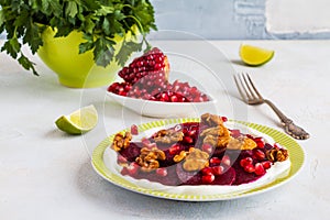 Dietary vegetarian salad of roasted beets with pomegranate seeds, walnuts caramelized in honey and natural yoghurt.