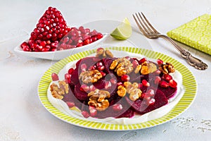 Dietary vegetarian salad of roasted beets with pomegranate seeds, walnuts caramelized in honey and natural yoghurt.