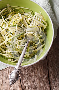 Dietary zucchini pasta in a bowl closeup. vertical top view