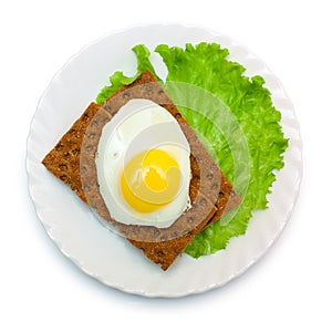 Dietetic lunch: fried egg, lettuce, crisp bread on plate