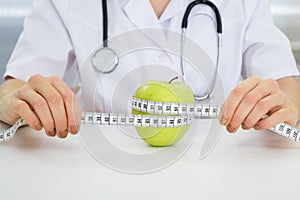 Dietician measuring green apple photo