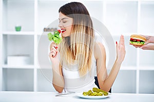 Dieting concept, beautiful young woman choosing between healthy
