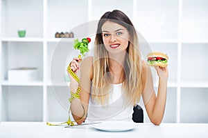 Dieting concept, beautiful young woman choosing between healthy