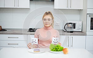 Dieting concept, beautiful young woman choosing between healthy food and junk food