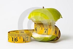 Dieting concept Green apple with measuring tape