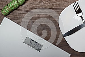 Dieting concept with scales on wooden floor