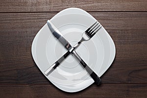 Dieting concept white plate with knife and fork