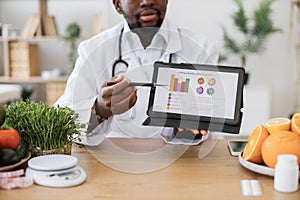 Dieting expert showing scale of obesity on digital tablet