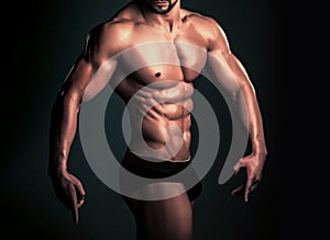 Dieting and fitness, healthy lifestyle. Athletic bodybuilder man on black background. Man with muscular body and torso