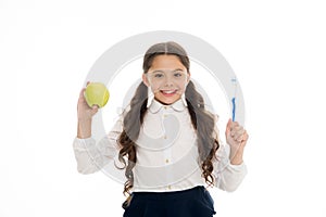 Dieting and health. Development of children. Little child smiling with tooth brush and green apple. Happy girl isolated