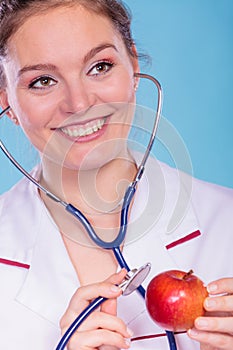 Dietitian examine apple fruit with stethoscope.