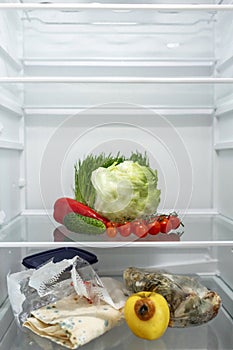 The difference between the produce shelf with fresh vegetables and the shelf with rotten packaged products in the refrigerator.