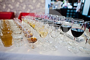 Different alcohol beverages in glasses on the table in restaurant or bar.